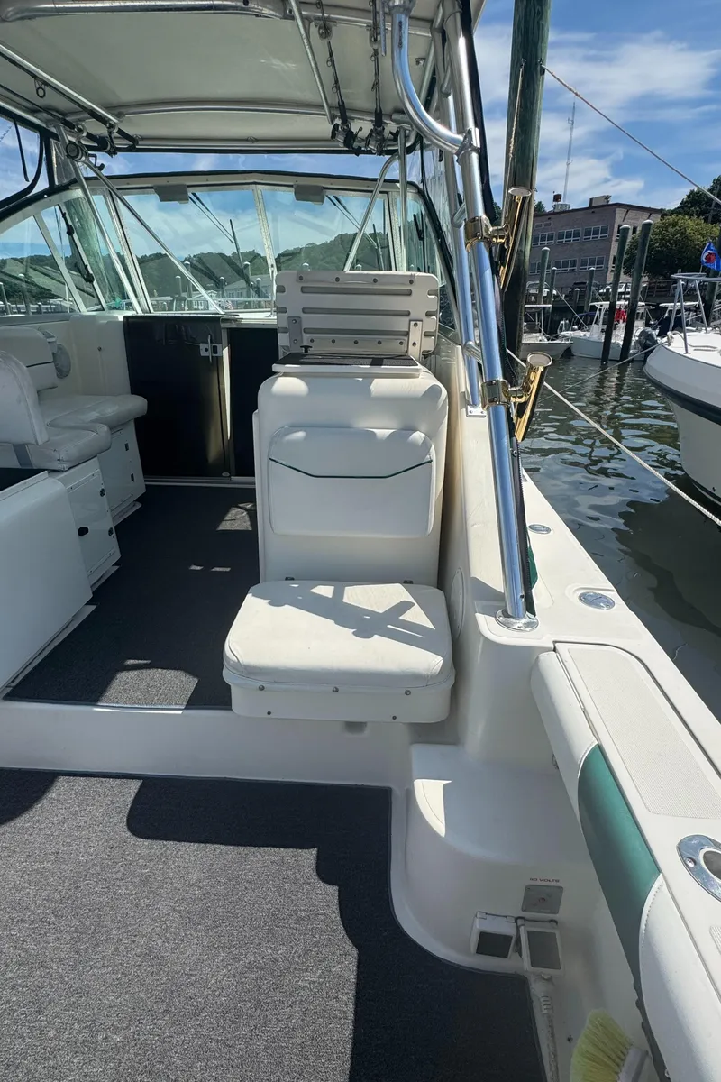 Slide: The Image of 2002 Pursuit 3000 Express boat interior with seating and helm, docked at marina. - 9