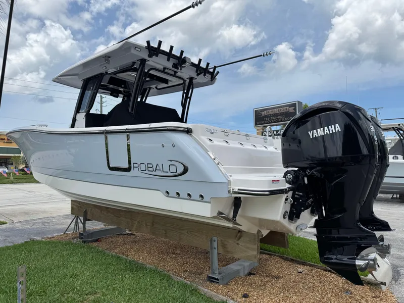 Slide: The Image of 2025 Robalo R300 Center Console boat with Yamaha engines on display outdoors. - 0