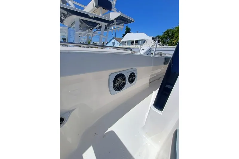 Slide: The Image of 2025 Robalo R300 Center Console boat interior with speakers, white and blue design. - 14