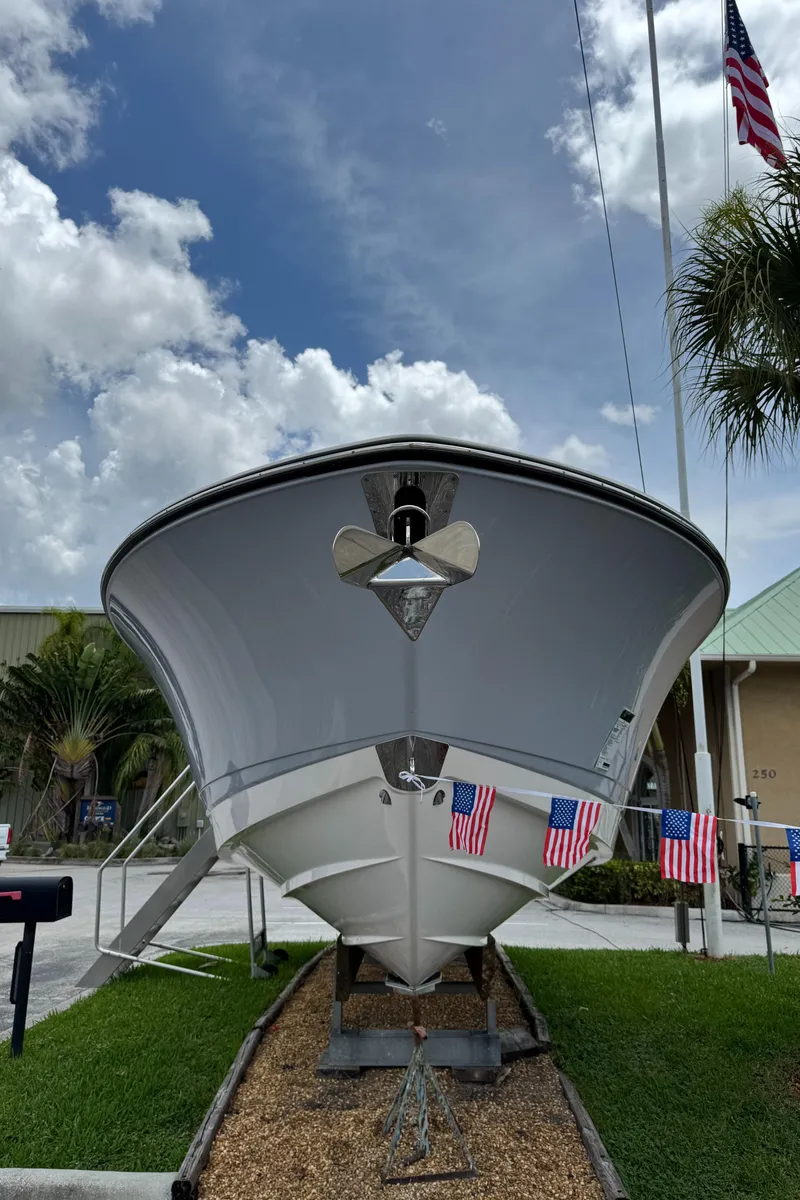Slide: The Image of 2025 Robalo R300 Center Console boat displayed outdoors with American flags. - 2