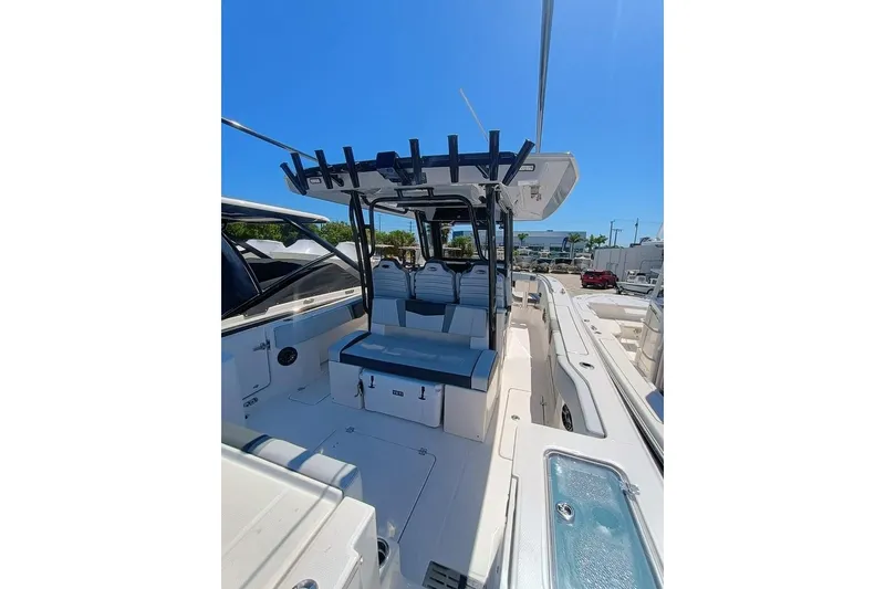 Slide: The Image of 2025 Robalo R300 Center Console boat interior with seating and storage, under clear blue sky. - 21