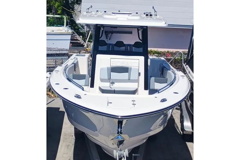 Slide: The Image of 2025 Robalo R300 Center Console boat, sleek design, white exterior, docked outdoors. - 6