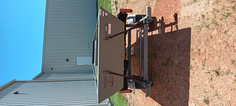 Slide: The Image of Tracker 1542 JON boat, 2026 model, on a trailer near a metal building. - 14