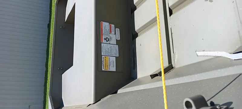 Slide: The Image of 2026 Tracker 1542 JON boat interior with safety labels and yellow rope. - 3