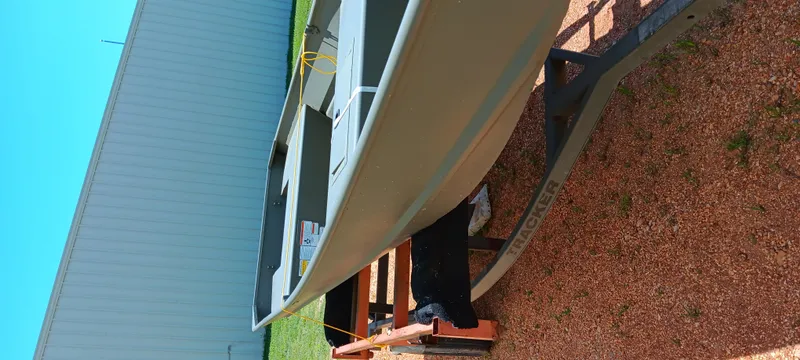 Slide: The Image of 2026 Tracker 1542 JON boat on trailer, parked outdoors near a building. - 5