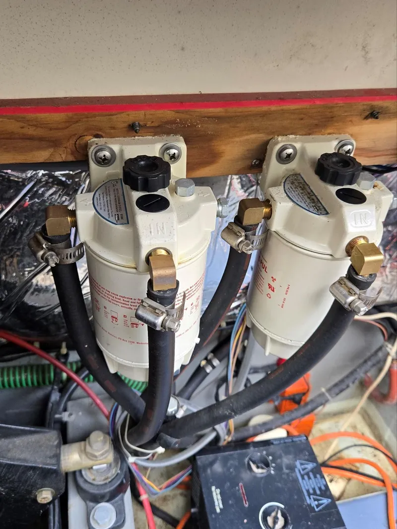 Slide: The Image of 1990 Tollycraft Sport Sedan engine compartment with dual fuel filters and hoses. - 21