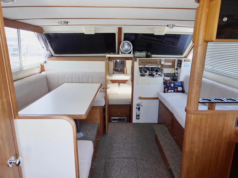 Slide: The Image of 1990 Tollycraft Sport Sedan interior with dining area and helm station. - 28