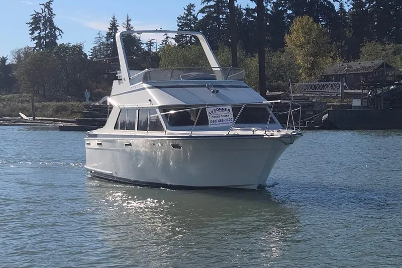 Slide: The Image of 1990 Tollycraft Sport Sedan yacht on calm water, surrounded by trees and docks. - 3