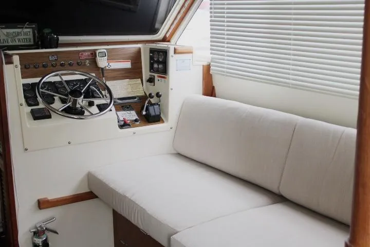 Slide: The Image of 1990 Tollycraft Sport Sedan interior with steering wheel and cushioned seating. - 30