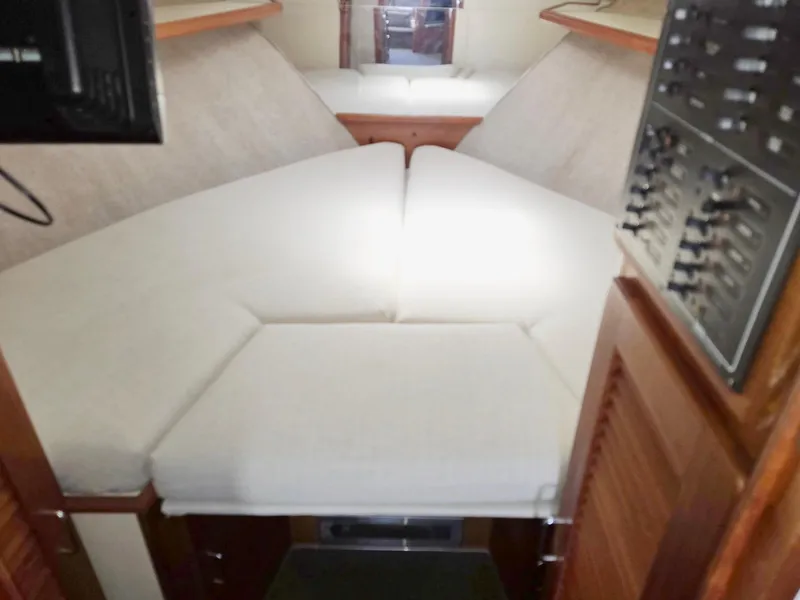 Slide: The Image of 1990 Tollycraft Sport Sedan cabin interior with cushioned bed and control panel. - 49