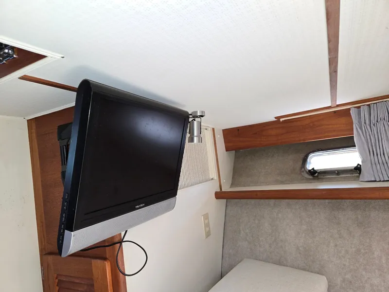 Slide: The Image of 1990 Tollycraft Sport Sedan interior with mounted TV and window. - 51