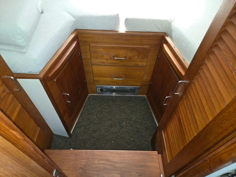 Slide: The Image of 1990 Tollycraft Sport Sedan interior with wooden cabinets and drawers. - 52