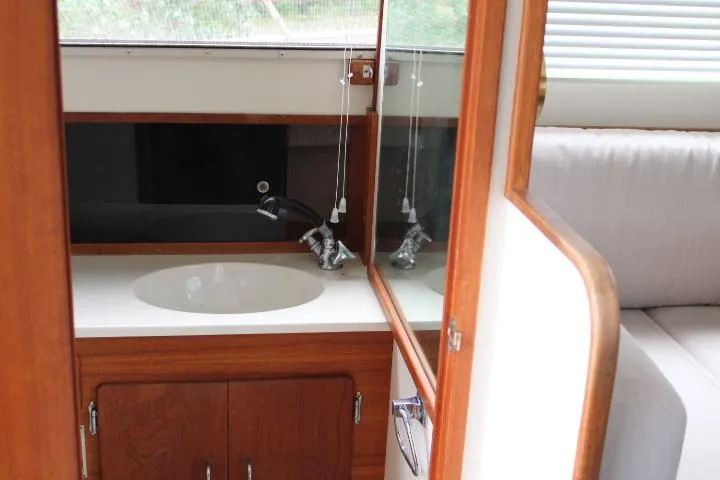 Slide: The Image of 1990 Tollycraft Sport Sedan interior with wooden cabinetry and sink. - 53