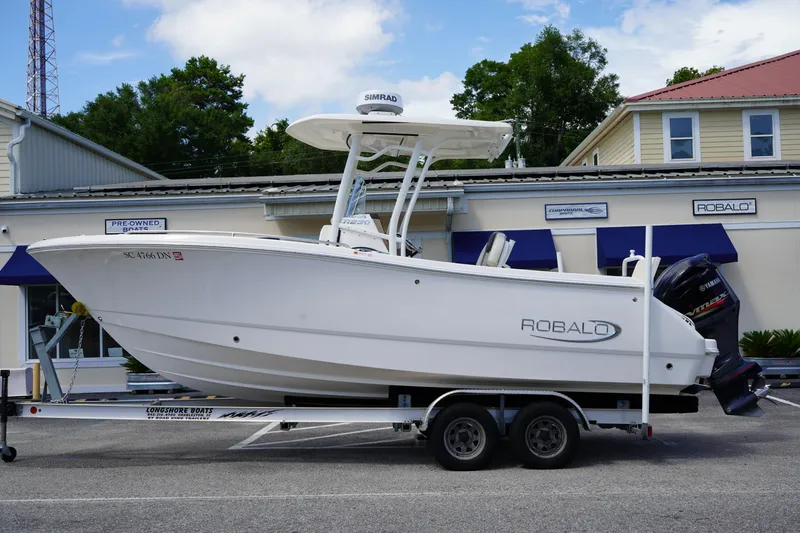 The Image of 2021 Robalo R230 Center Console boat on trailer, parked outside dealership. - 0