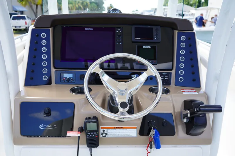 Slide: The Image of 2021 Robalo R230 Center Console boat dashboard with steering wheel and navigation controls. - 14
