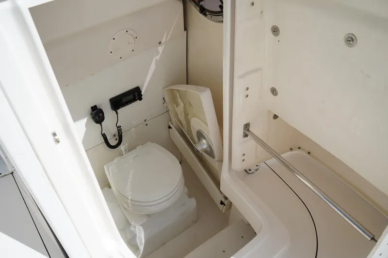Slide: The Image of 2021 Robalo R230 Center Console boat interior with toilet and radio equipment. - 26
