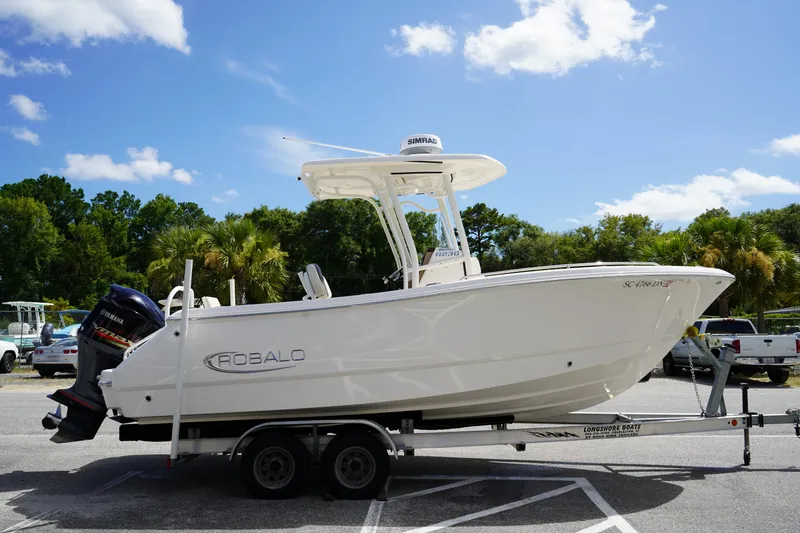 Slide: The Image of 2021 Robalo R230 Center Console boat on trailer, parked outdoors under blue sky. - 3