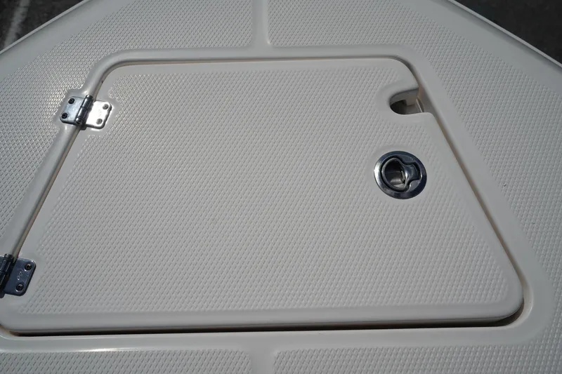 Slide: The Image of 2021 Robalo R230 Center Console boat hatch with textured surface and metal latch. - 33