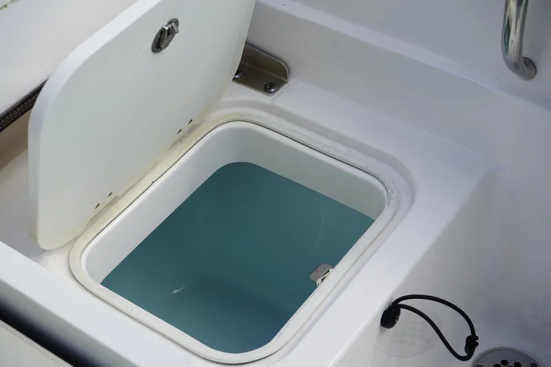 Slide: The Image of Livewell compartment on 2021 Robalo R230 Center Console boat, open lid, filled with water. - 7