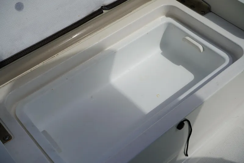 Slide: The Image of 2021 Robalo R230 Center Console storage compartment, open and empty. - 8