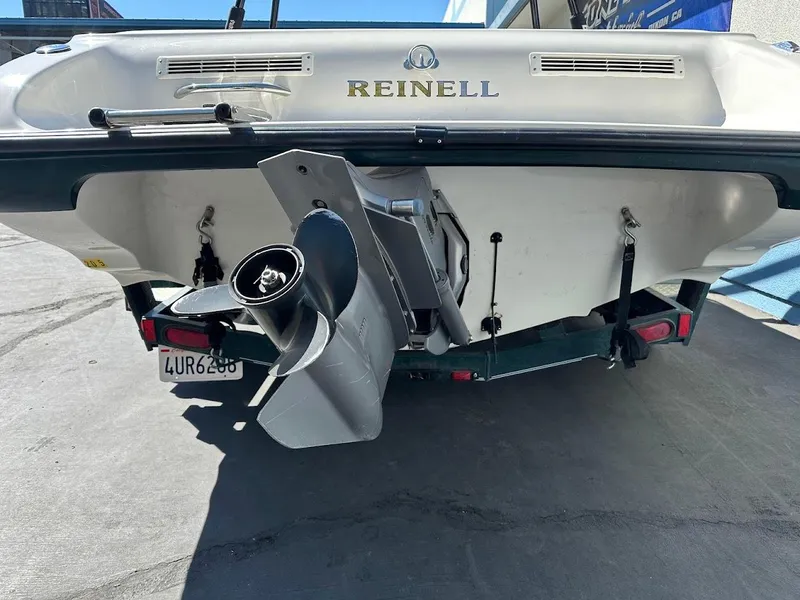 Slide: The Image of Rear view of a 2001 Reinell 203 boat with visible propeller and trailer. - 10