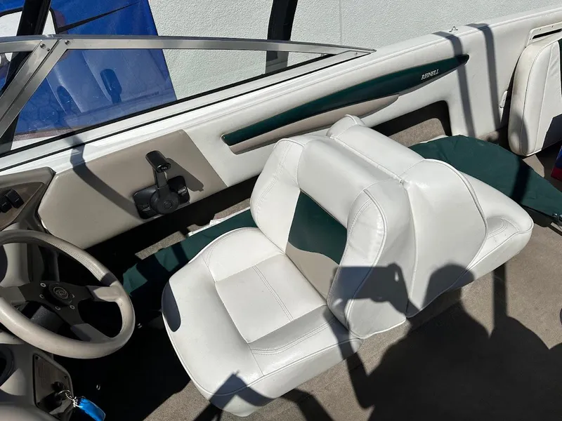 Slide: The Image of Interior of a 2001 Reinell 203 boat with white seating and steering wheel. - 19