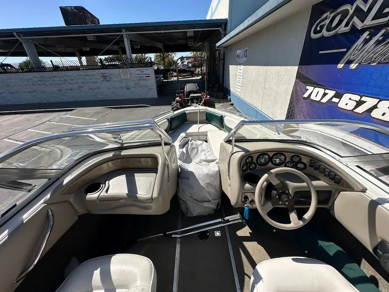 Slide: The Image of 2001 Reinell 203 boat interior with steering wheel and dashboard, parked outdoors. - 25