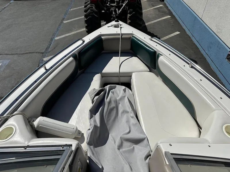 Slide: The Image of 2001 Reinell 203 boat interior with white and green seating, parked in a lot. - 26