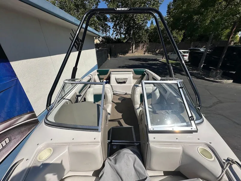 Slide: The Image of 2001 Reinell 203 boat interior with open seating and windshield, parked outdoors. - 27