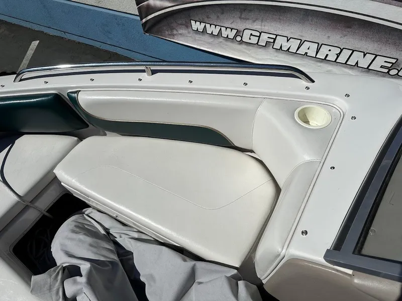 Slide: The Image of 2001 Reinell 203 boat interior with white and green seating, cup holder, and storage compartment. - 28
