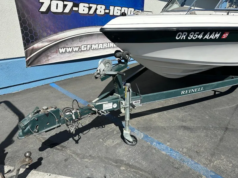 Slide: The Image of 2001 Reinell 203 boat on trailer, parked in lot with visible contact information. - 4