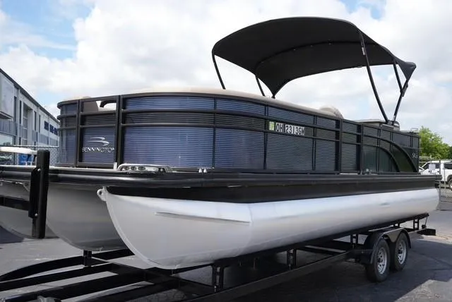 Slide: The Image of 2019 Bennington 25' Pontoon boat on trailer with canopy, parked outdoors. - 1