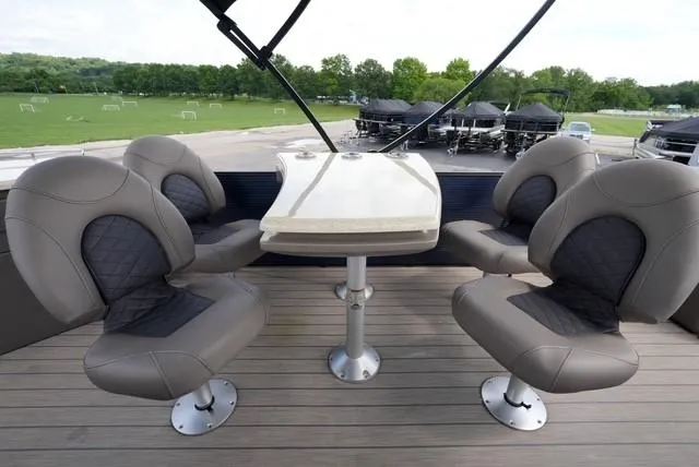 Slide: The Image of 2019 Bennington 25' Pontoon interior with four cushioned seats and a central table. - 13