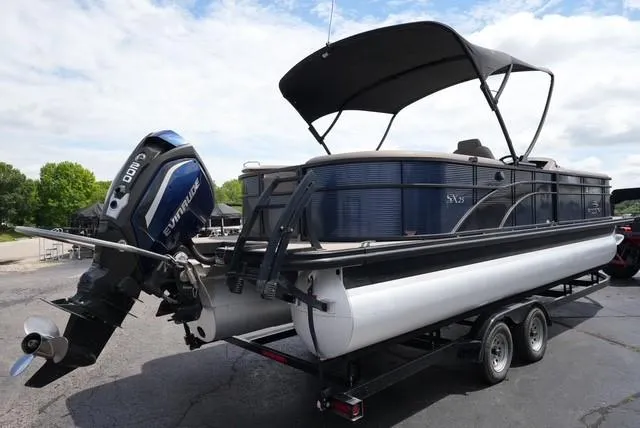 Slide: The Image of 2019 Bennington 25' Pontoon boat with Evinrude motor on trailer, under a blue sky. - 4