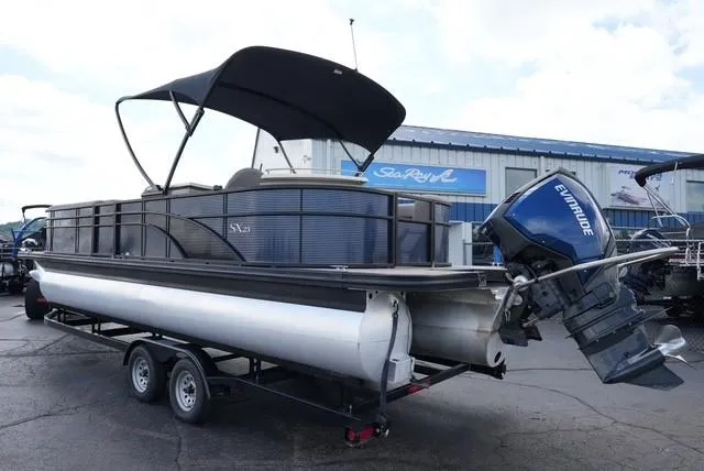 Slide: The Image of 2019 Bennington 25' Pontoon boat with Evinrude motor on trailer, parked outside dealership. - 6