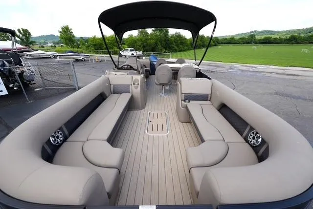 Slide: The Image of 2019 Bennington 25' Pontoon boat with spacious seating and sleek design, docked outdoors. - 7