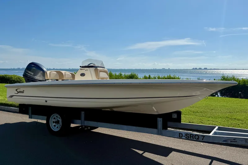 The Image of 2026 Scout 177 Sport boat on trailer by waterfront, clear sky background. - 0
