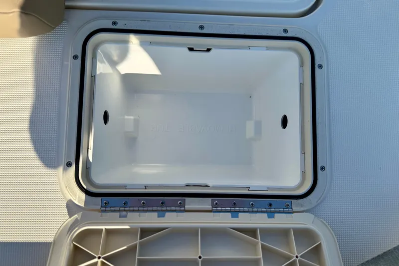 Slide: The Image of Open storage compartment on 2026 Scout 177 Sport boat, featuring a white interior. - 11