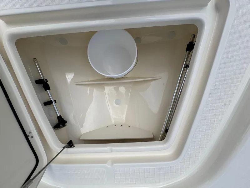 Slide: The Image of Storage compartment of 2026 Scout 177 Sport boat, featuring hydraulic supports and a bucket. - 21