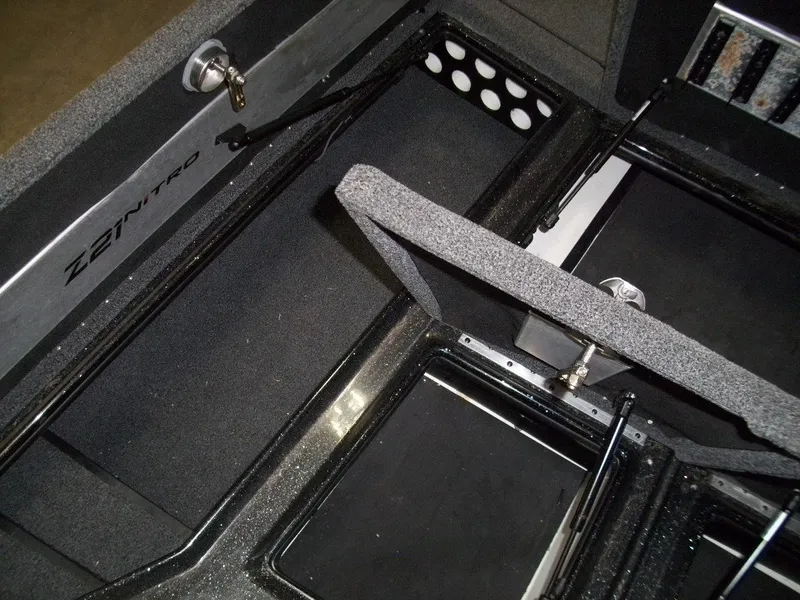 Slide: The Image of 2021 Nitro Z21 boat storage compartments with open hatches and secure locks. - 12