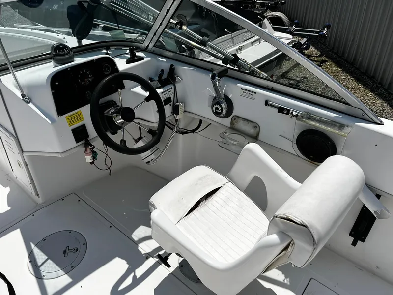 Slide: The Image of 1997 Boston Whaler 20 Dauntless boat cockpit with steering wheel and controls. - 12