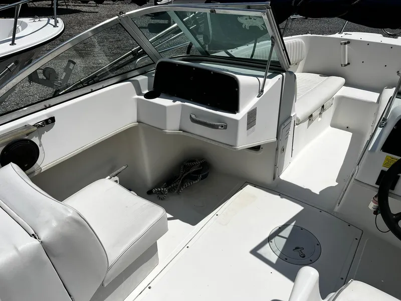 Slide: The Image of 1997 Boston Whaler 20 Dauntless boat interior with white seating and steering console. - 13