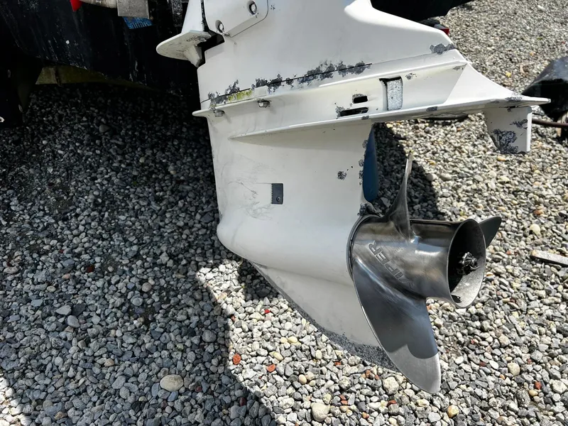 Slide: The Image of 1997 Boston Whaler 20 Dauntless boat propeller on gravel surface. - 17