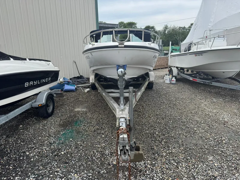 Slide: The Image of 1997 Boston Whaler 20 Dauntless boat on trailer, parked between other boats. - 3