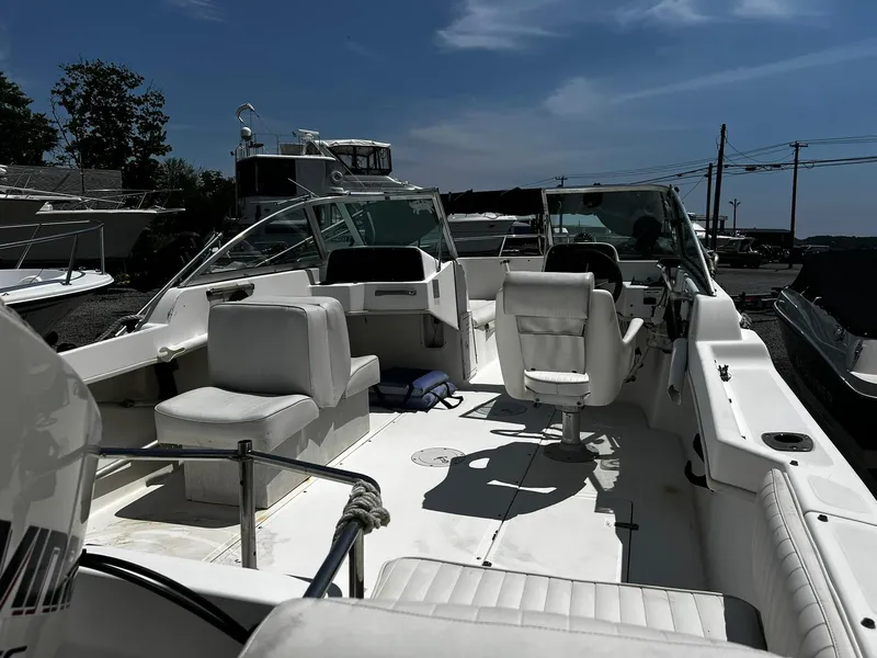 Slide: The Image of 1997 Boston Whaler 20 Dauntless boat interior with seating and steering wheel under clear sky. - 5