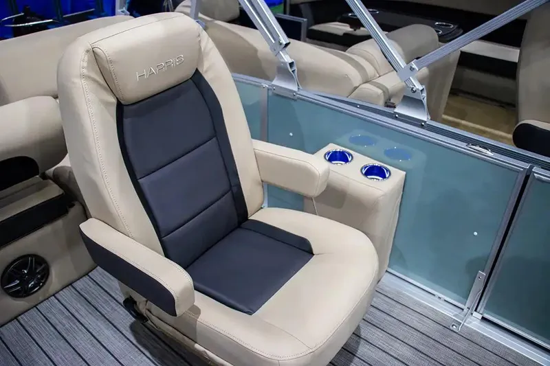 Slide: The Image of 2024 Harris Cruiser 230 boat seat with cup holders, beige and black design. - 16
