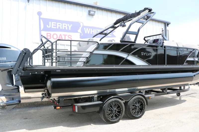 Slide: The Image of 2025 Sylvan L3 CLZ DH pontoon boat on trailer, displayed at Jerry White Boats dealership. - 2