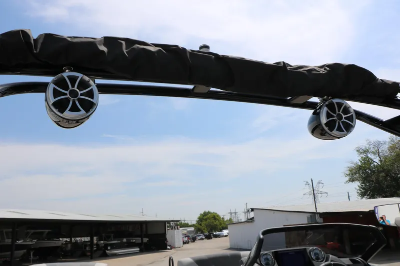 Slide: The Image of 2025 Sylvan L3 CLZ DH boat with mounted speakers and canopy, parked outdoors. - 34