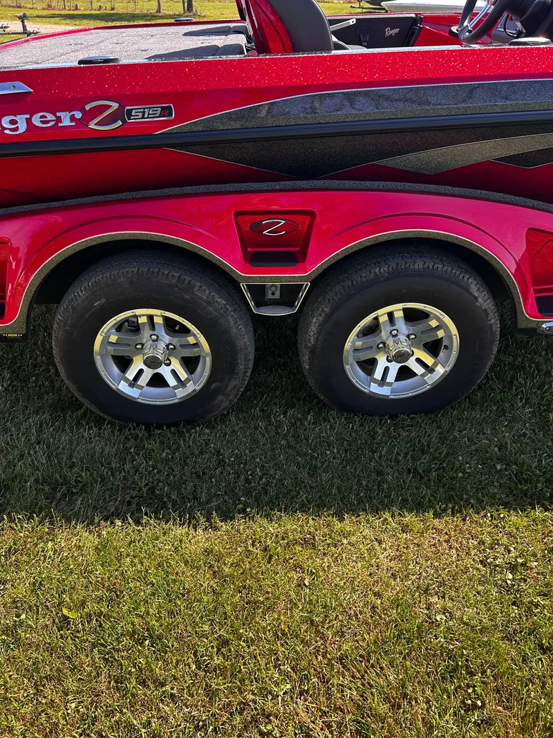 Slide: The Image of 2024 Ranger Z519 boat trailer with dual wheels on grass. - 25