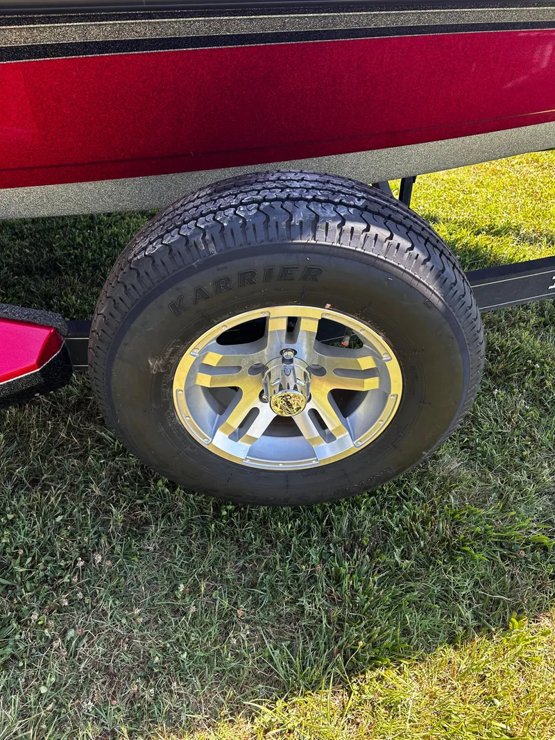 Slide: The Image of 2024 Ranger Z519 boat trailer wheel on grass, featuring Karrier tire and alloy rim. - 26